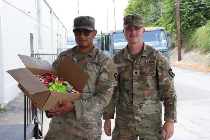 Two service members holding a box of donated candy, from the Soldiers’ Angels website